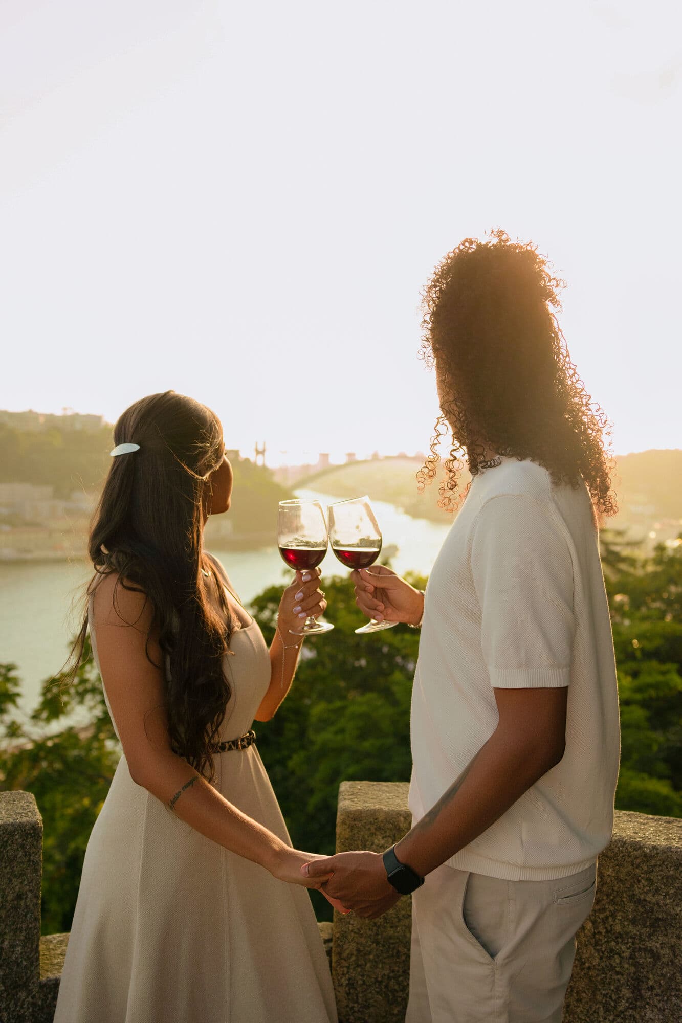 Janaina e Michael brindando ao pôr do sol com vista para o rio